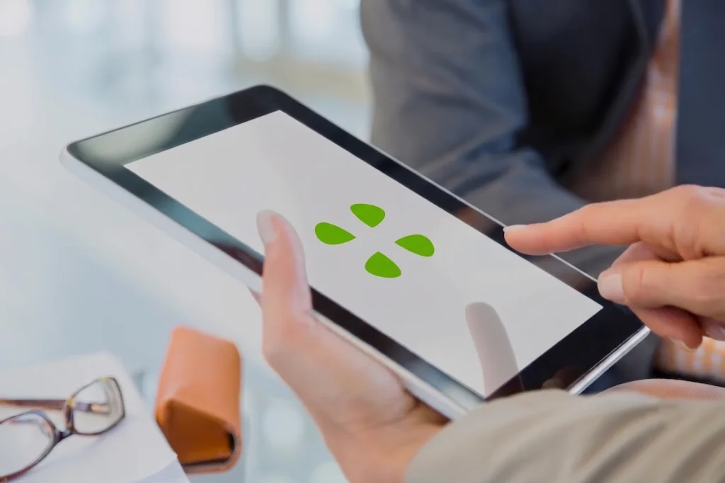 Persona utilizando una tableta digital que muestra el software edatf con un panel de control para optimizar, automatizar y escalar la formación bonificada y gestión con FUNDAE.